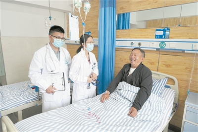 图为5月16日上午，老李与前来查房的医生交流。本报记者 瞿芃 摄